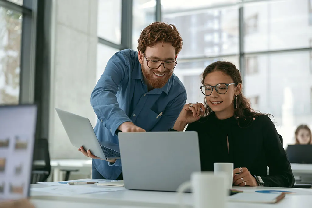 Zwei Personen besprechen Kennzahlen am Laptop